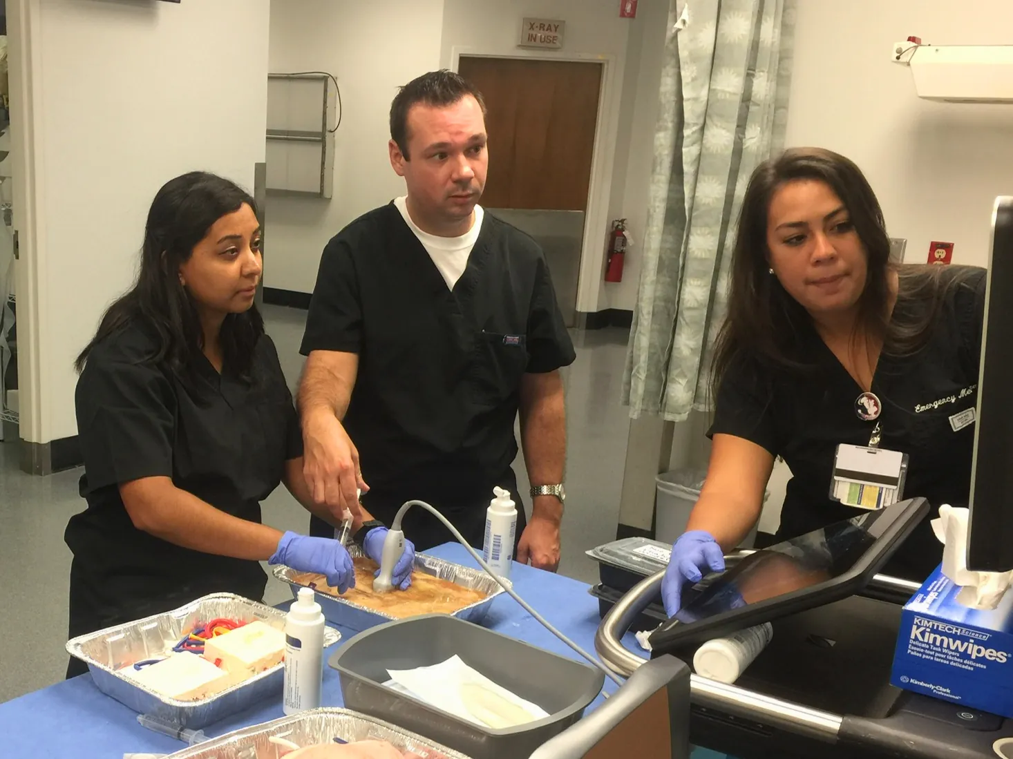 Faculty and residents practicing needle guidance on ultrasound phantoms